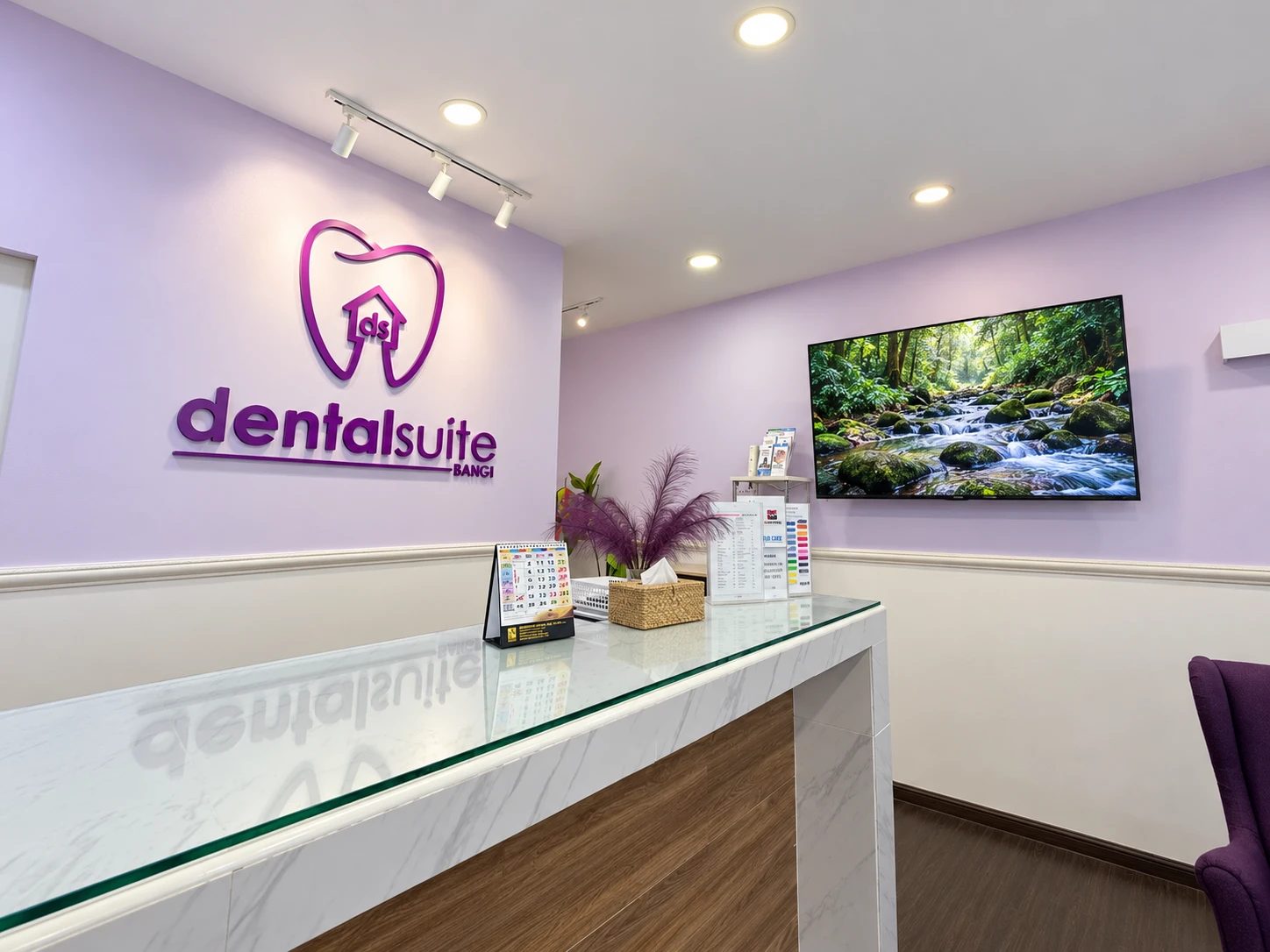 Reception counter with Dental Suite Bangi logo wall